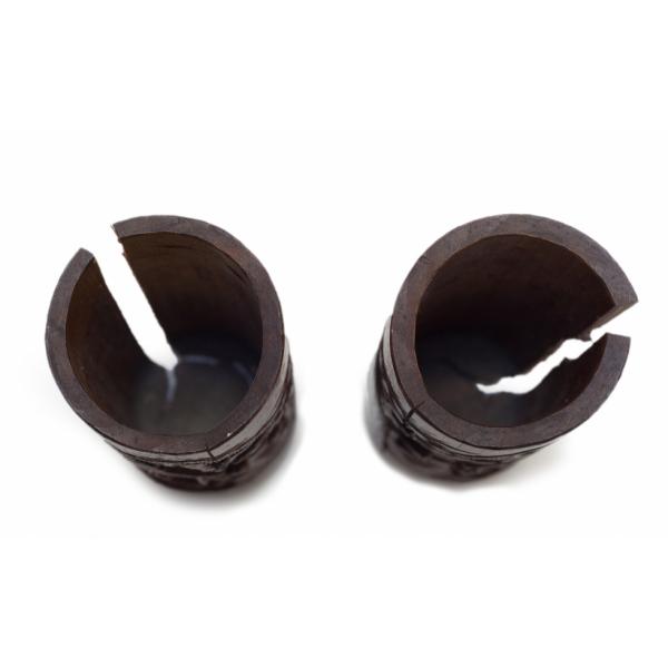 The tops of two wooden vases. They are dark brown and circular. There is a section cut out of the length of each.