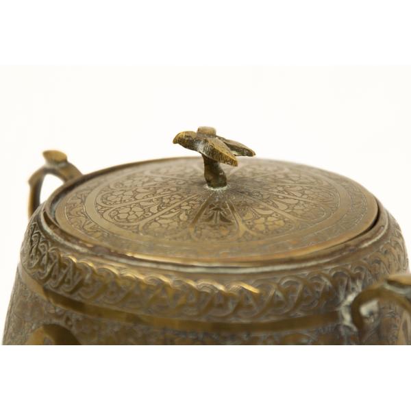 A bird, possibly a falcon, on the top of the lid of the sugar bowl. There is a floral pattern on the lid. |  