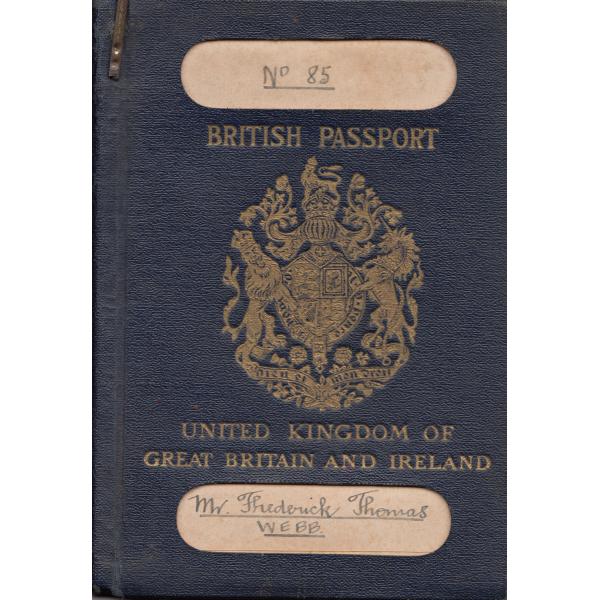 La couverture d'un passeport britannique délivré à Frederick Thomas Webb. Il est de couleur marine avec une écriture en or et un blason. Il y a deux autocollants de couleur claire avec des titres écrits à la main.