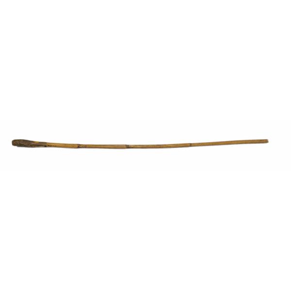 A walking cane that is yellowish in colour and is made of bamboo with a slight curve in the centre. 