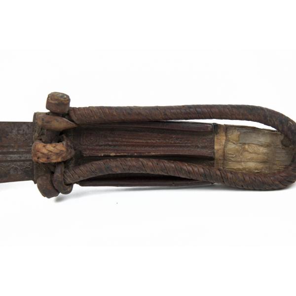 The twisted rope handle on the sheath of the knife. It is dark brown and attached to the leather sheath. 