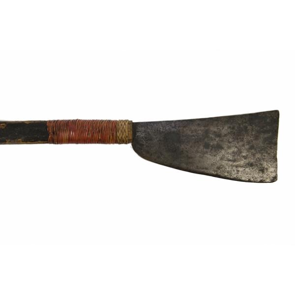 The metal blade of an axe, attached to a dark wooden handle with red string wrapped around its end. The blade is short and wide. It is flat on the top and the end, and it is curved at the bottom.