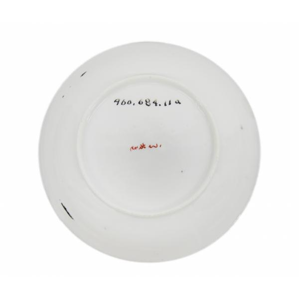 The back of a saucer showing the maker's mark written in red, in an Asian script.  