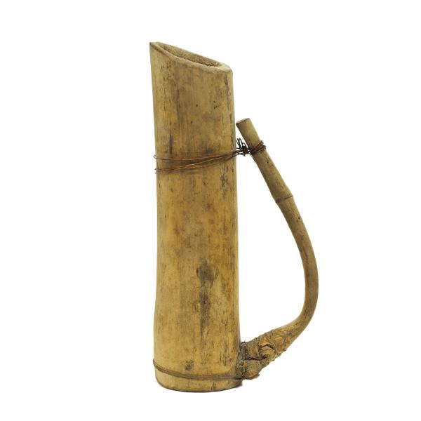 Pichet brun pâle en bambou, avec l’anse vers la droite. L'anse est faite d'une branche qui sort du tronc principal et qui a été recourbée vers l’arrière et fixée avec du fil de cuivre. 