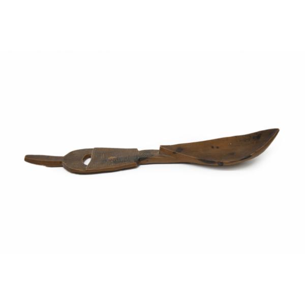 Side view of a carved wooden spoon. The bowl is curved and the handle is flat with a design incised onto it. There is a hole carved into the handle. 