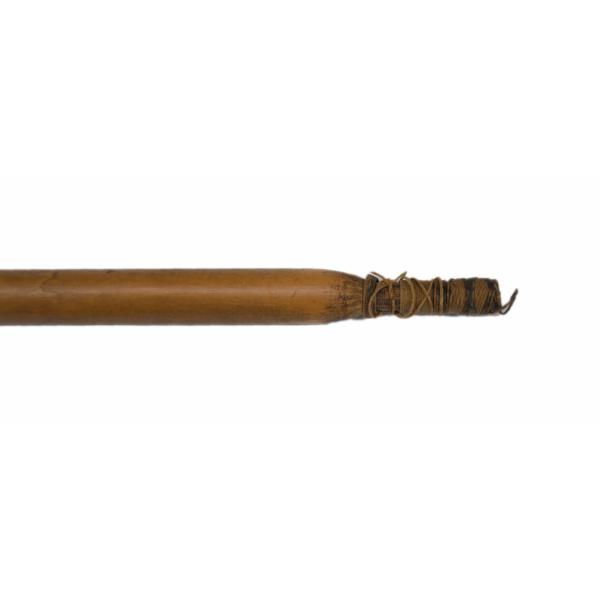 The end of a brown wooden fishing spear. The end is narrower than the shaft and there is brown string wrapped around it.