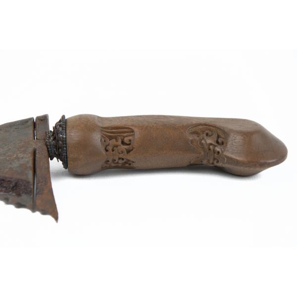 The carved wooden handle of a knife. The carvings are symmetrical. 