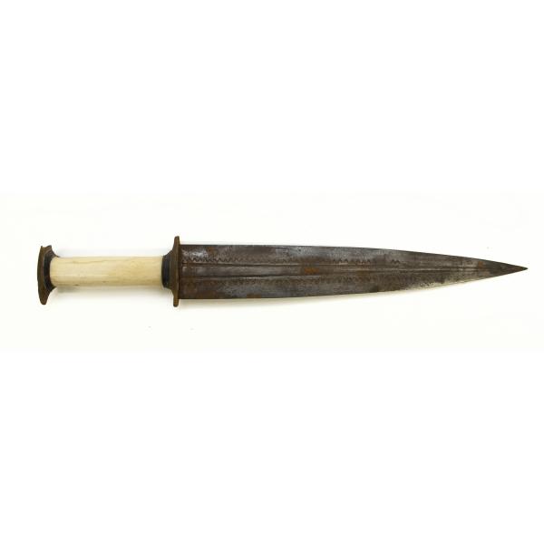 A metal dagger with an ivory handle pointing right. The blade is symmetrical and there are two grooves running the length of the blade. There is a "v" pattern towards the edge of the blade. 