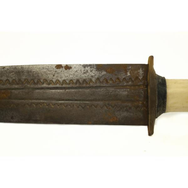 A metal blade with two channels running along the centre. There is a decorative "v" pattern on the outside of the grooves. 