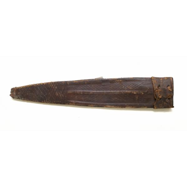 A leather sheath from a dagger pointing left. The tip is decorated with crosshatching and the body has a series of lines that form an "X". There are four holes at the opening end with pieces of leather string in them.