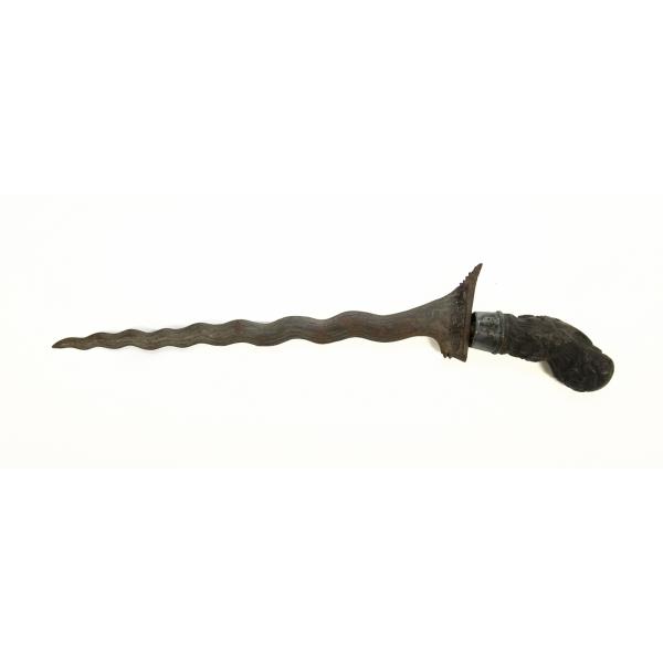 A metal dagger with a wavy blade and a carved wooden handle, pointing to the left. 