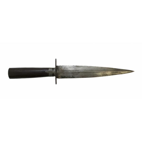 A metal dagger, pointing to the right. It has a dark wood handle. The blade is symmetrical and there are two rows of dots down its length. 