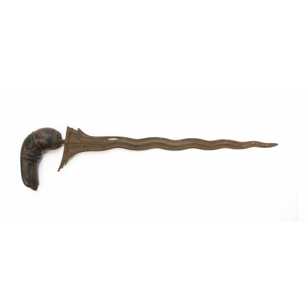 A metal dagger with a wavy, rusted blade that has a hole in it. The wooden handle is curved and carved. 