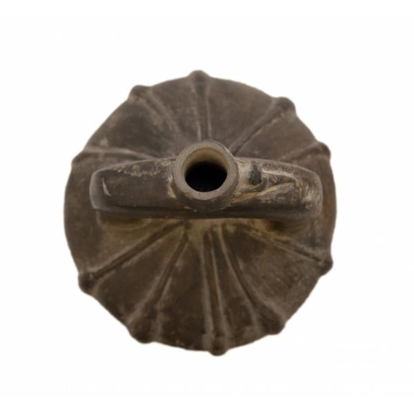 Top view of the dark brown stirrup-spout bottle. Decorated with a low-relief, radiating pattern. 