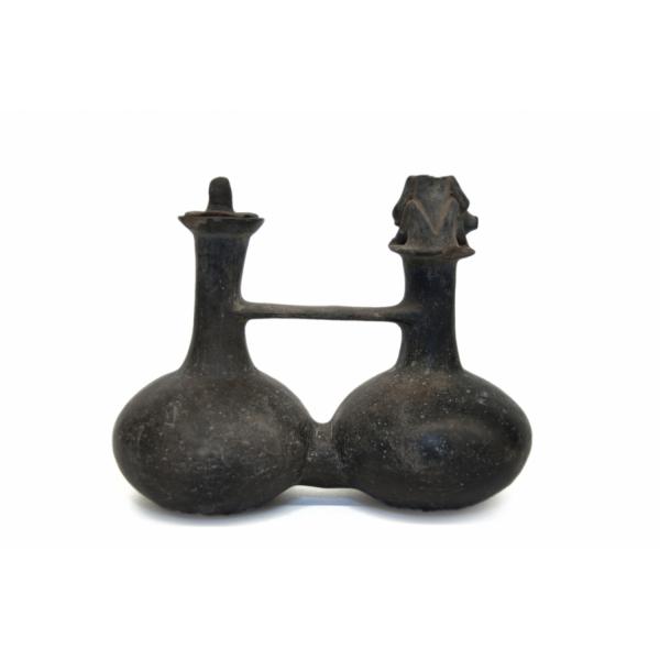 Back side of black double-spout and bridge vessel. There is a kneeling figure, missing its head, on the spout to the right. 