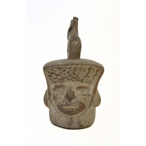 Front side of the portrait-head vessel with eyes, nose, mouth, and ears. The spout sits on top of the head.