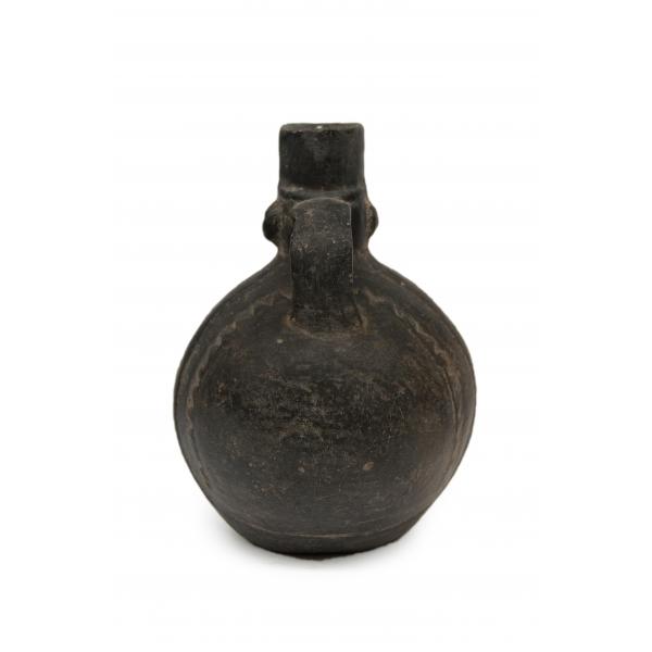 Back side of black portrait-head vessel showing small loop handle.