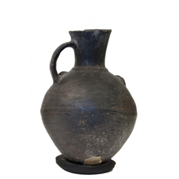 Back view of black stirrup-handle jug showing smooth back side. 