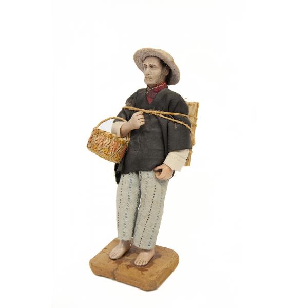 Figurine en argile peinte d’un homme portant un chapeau de paille et un panier.