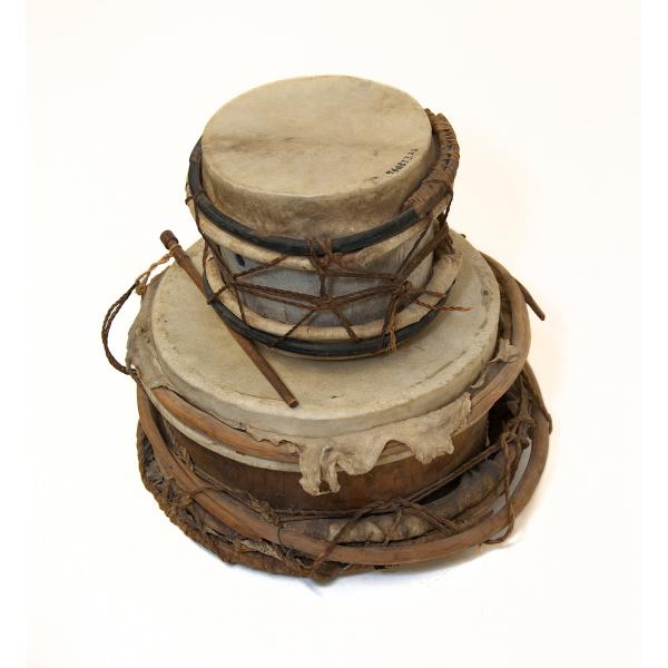 Two stacked drums seen on an angle. Skins have been stretched across the tops and they are head together with string or hemp.