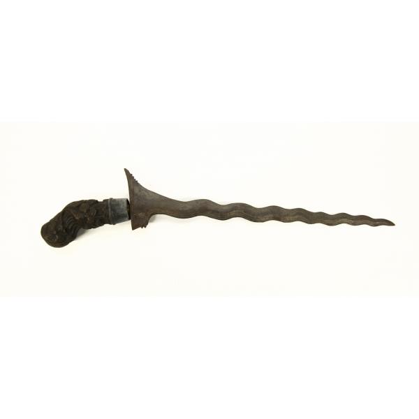 A metal dagger with a wavy blade and a carved wooden handle, pointing to the right.