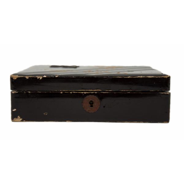 The front of a black box showing the lock. The lock is rusted and the black paint is chipped around the corners and opening. 