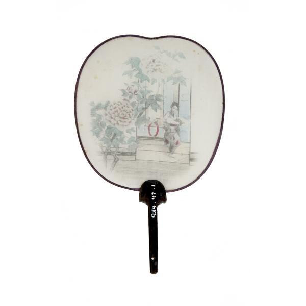 The back of a white fan with a black handle spread open on a blue background. An image of a Japanese woman inside the door of a building with a flowering tree outside is printed on the fan.  