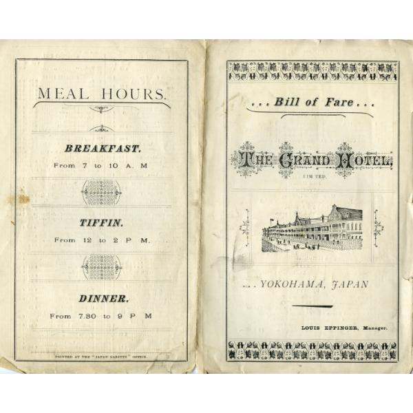 The cover of a bill of fare for The Grand Hotel. On the right, there is an image of a two-story building with people on the street in front of it. A border of leaves is drawn at the top and bottom. The left side lists the times that meals are served. 