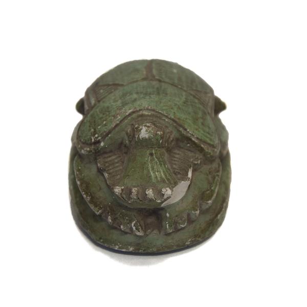 Front view of a green-painted scarab. The head of the scarab is visible. 