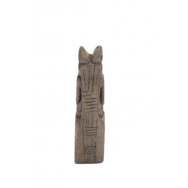 L’arrière d’une statuette d’Anubis assis montrant les gravures décoratives simples. Des lignes verticales se trouvent près de la tête, et les lignes horizontales sont près de ses épaules. 