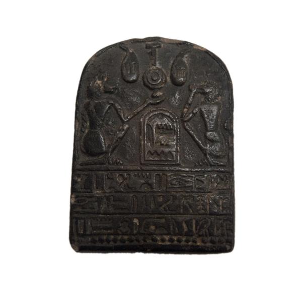 Black steatite stele carved with a raised relief depicting two baboons and three rows of hieroglyphic text.  