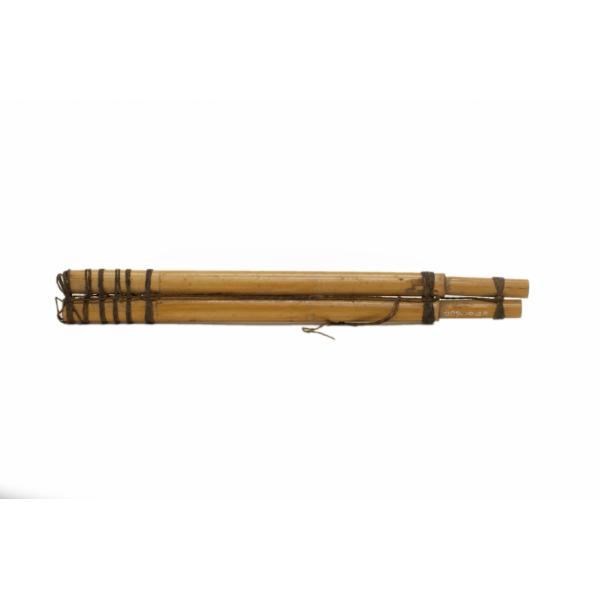 The back of  two bamboo flutes tied together with string. 