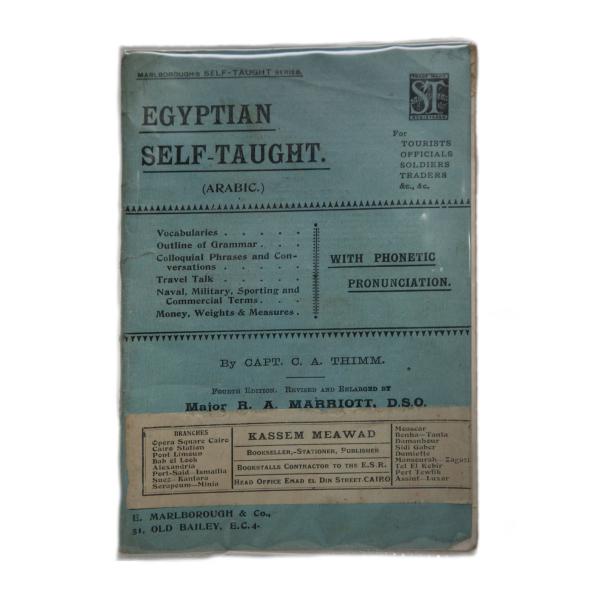 La couverture du livre intitulé « Égypteian Self-Taught » (Égyptien autodidacte). Elle est bleue et un étiquette beige indique la librairie où le livre a été acheté.