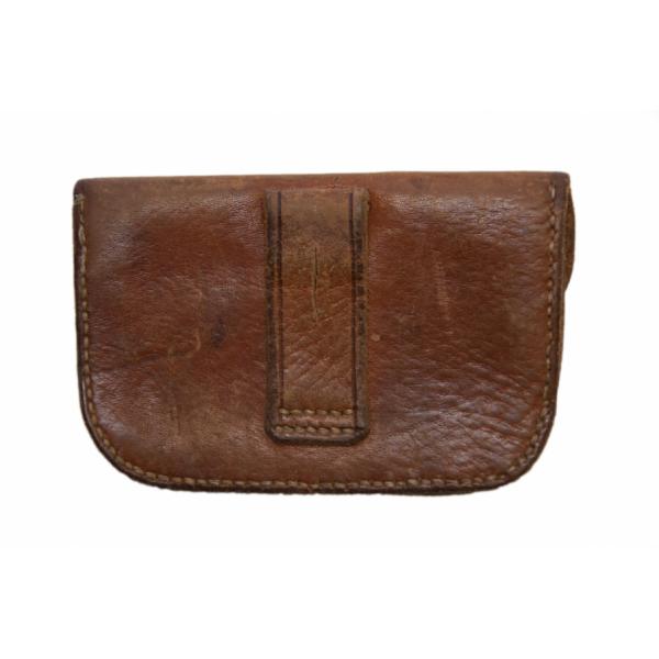 The back of a brown leather pouch showing a belt loop sewn onto the centre of the pouch.