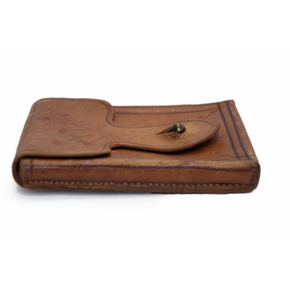 The side of a rectangular brown-leather pouch. The button is sticking up from the flap. 