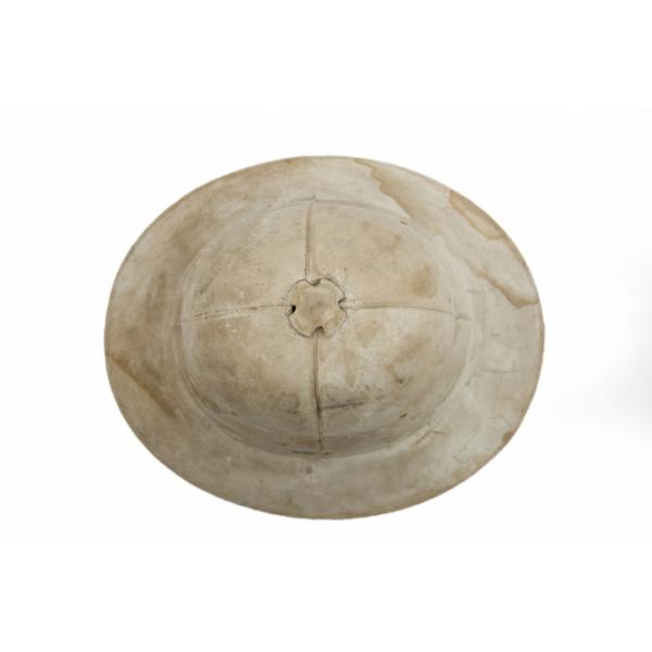 A top view of a white pith helmet showing the air vent. It is well worn and dirty.