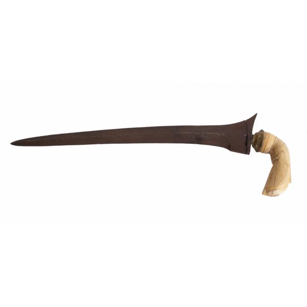 A metal dagger with an ivory handle, pointing to the left. The blade is curved and rusted, and there is a swirling pattern in the metal.  