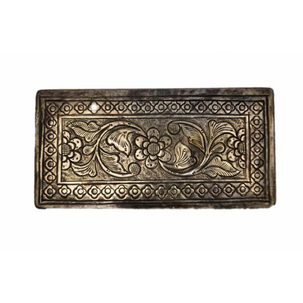 Bottom view of the silver cigarette case carved with a floral design.