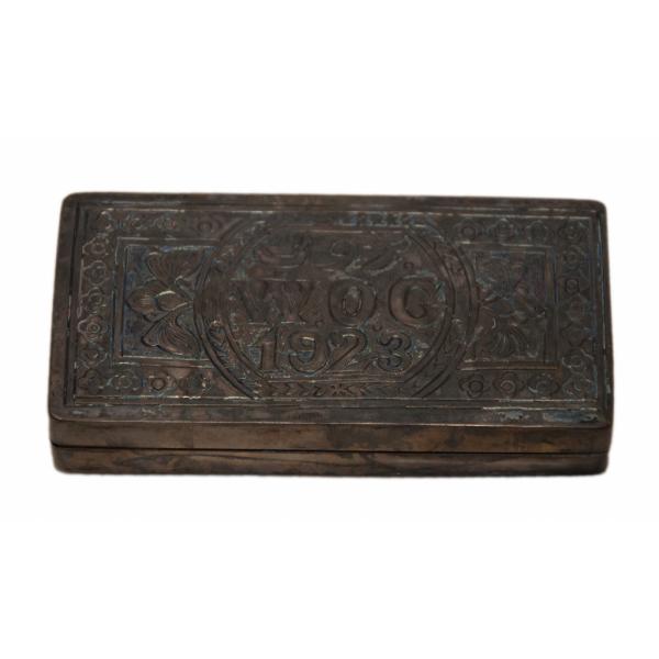 Three-quarter view of the cigarette case incised with a floral design and William Gillespie's initials and the year "1923". 