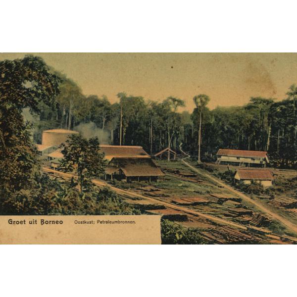 Une carte postale montrant cinq bâtiments et un grand réservoir de stockage dans une clairière. Il y a deux routes. La carte postale indique : « Groet uit Borneo » et « Oostkust; Petroleumbronnen. » 