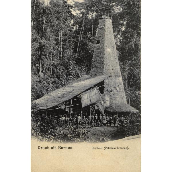 A group of people standing in front of a tall, thatched oil derrick. There is a mass of trees behind them. At the bottom it says: "Groet uit Borneo" and "Oostkust (Petroleumbronnen)". 