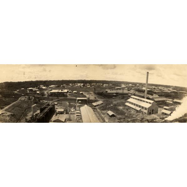 Photographie aérienne des installations de la Tropical Oil Company à El Centro, Colombie. On y voit des routes entrant et sortant de l’usine et une cheminée est fixée au plus gros bâtiment.