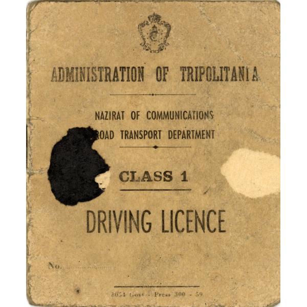 The cover of a driving licence. It is light brown and there is a black spot on the left side and a faded spot on the right. There is a crest at the top. The document reads: "Administration of Tripolitania. Nazirat of Communications Road Transport Department. Class 1 Driving Licence".