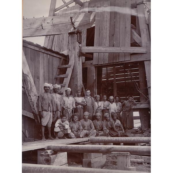 Harry Phillips and his crew posed in front of an oil rig. 