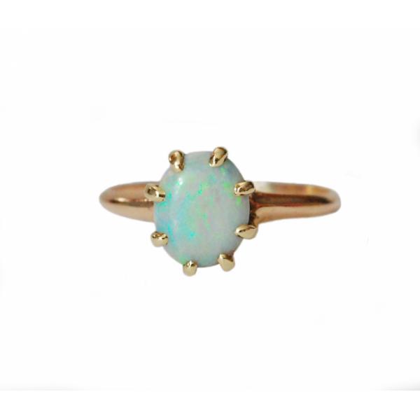 A green and blue stone set into a ring with eight gold prongs and a gold band.