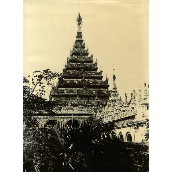 A building with a roof that has seven tiers. There are archways along the walls and the tiers are intricately carved.