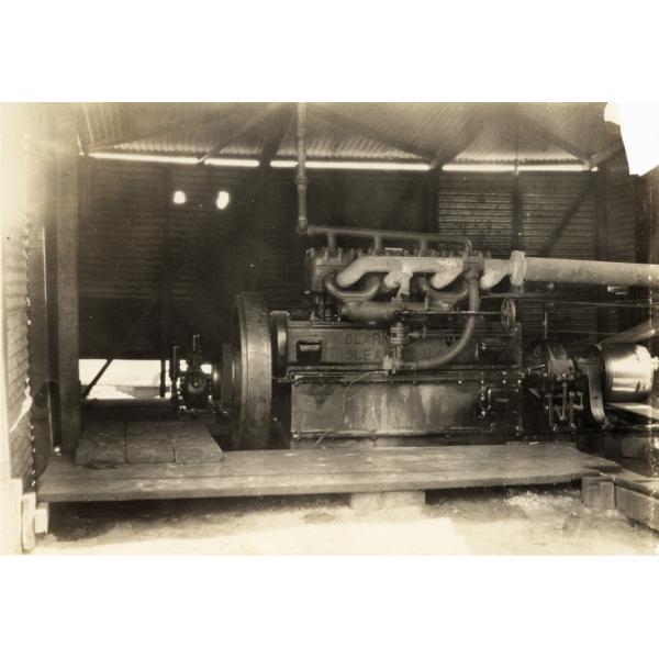 Engine inside a National Rig, with a large bull wheel on the left, and pipes running off to the right. 