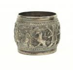 A silver napkin ring showing two figures stabbing a deer with daggers.