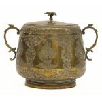 The front of a brass sugar bowl showing three medallions with the faces of bearded sultans. The handles are curved  and there is a bird on top of the lid. 