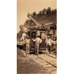 Four men standing in front of a rail car. 